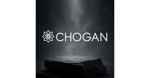 Logo Chogan posé sur une pierre sombre, dans un décor élégant avec fond brumeux, représentant l’univers raffiné des parfums Chogan